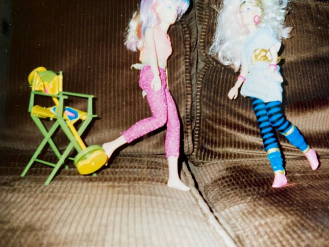 2 of the author's jem dolls with a director's chair on her old couch
